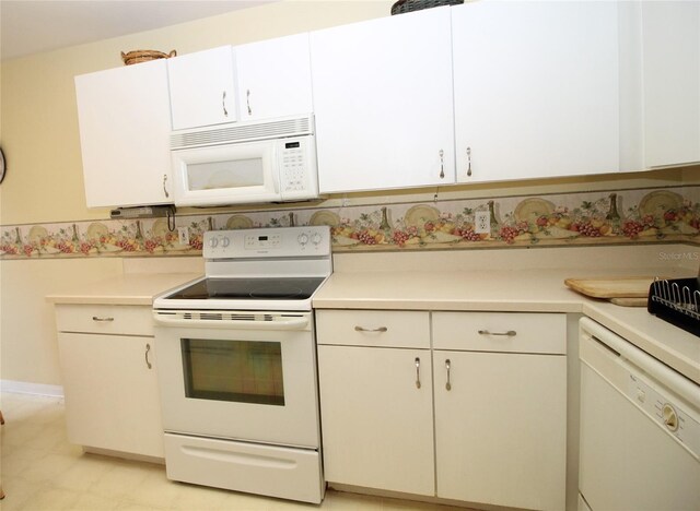 kitchen featuring white appliances, light tile patterned flooring, and white cabinetry