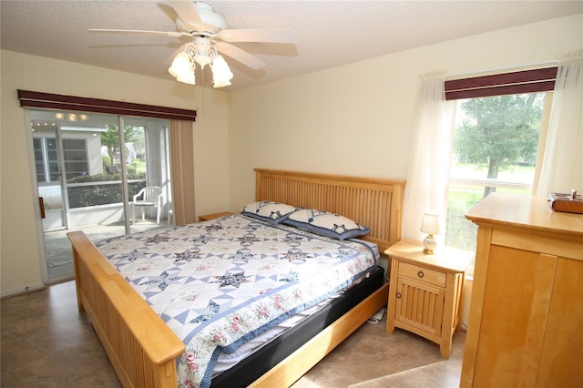 bedroom with multiple windows, a textured ceiling, access to exterior, and ceiling fan