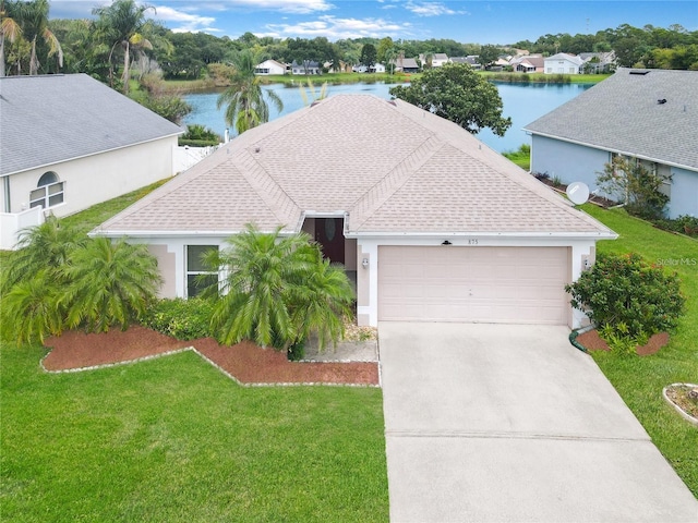 view of front of property with a water view, a front lawn, and a garage