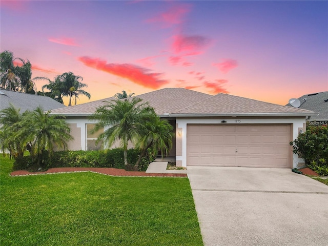 view of front of property featuring stucco siding, driveway, and a yard