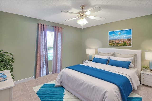 bedroom featuring light tile patterned floors, baseboards, a textured ceiling, and ceiling fan