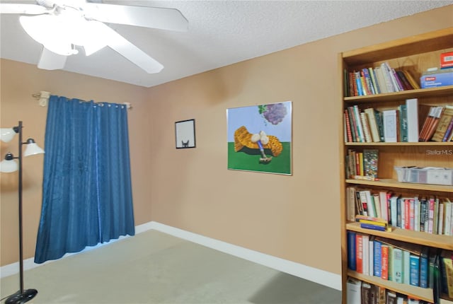 interior space with a textured ceiling and ceiling fan