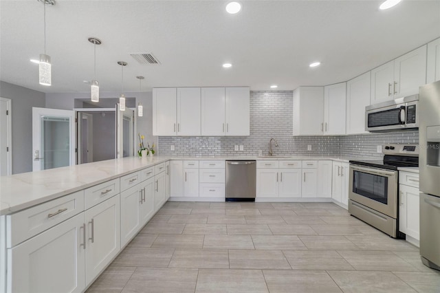 kitchen featuring white cabinets, pendant lighting, stainless steel appliances, and kitchen peninsula