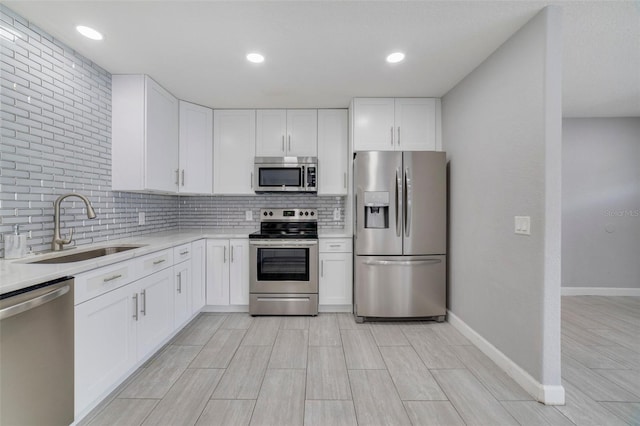 kitchen featuring white cabinets, decorative backsplash, sink, and appliances with stainless steel finishes