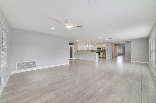 unfurnished living room with ceiling fan