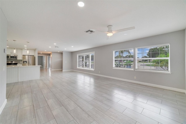 unfurnished living room with ceiling fan