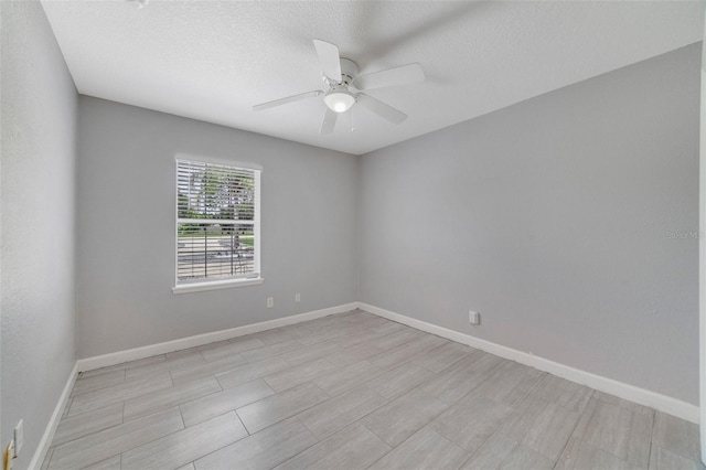 unfurnished room with ceiling fan, a textured ceiling, and light wood-type flooring