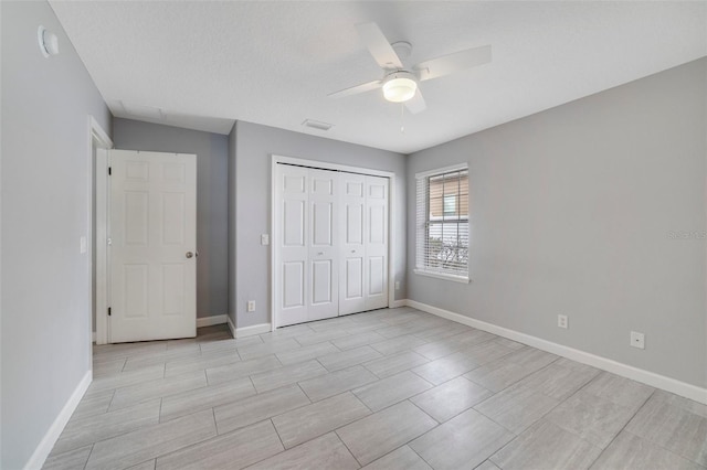 unfurnished bedroom featuring ceiling fan, a textured ceiling, and a closet