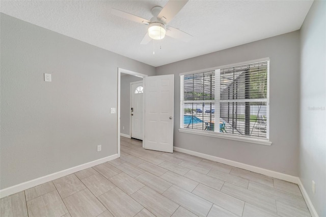 empty room featuring ceiling fan and a textured ceiling