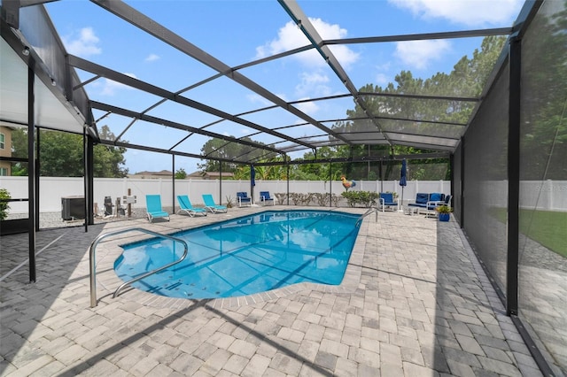 view of swimming pool with glass enclosure and a patio area