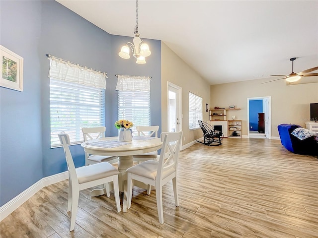 dining room with plenty of natural light, ceiling fan with notable chandelier, and light hardwood / wood-style floors