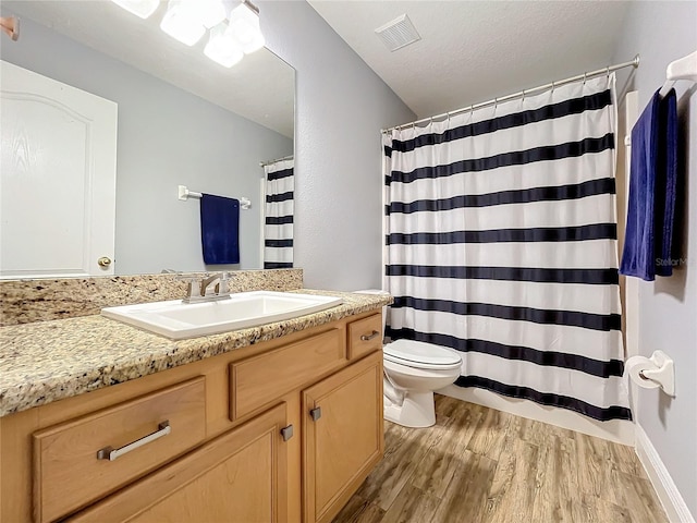 bathroom with a textured ceiling, vanity, toilet, a shower with curtain, and hardwood / wood-style flooring