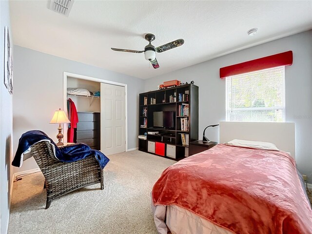 carpeted bedroom featuring ceiling fan and a closet