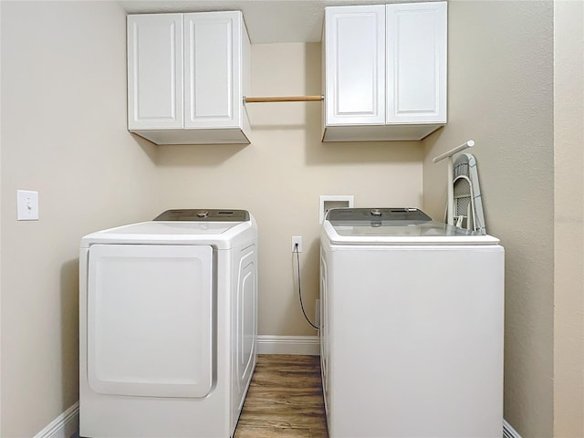 washroom with washer and dryer, cabinets, and light wood-type flooring