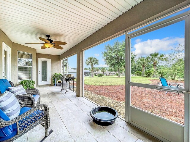 sunroom with a wealth of natural light, ceiling fan, and wooden ceiling