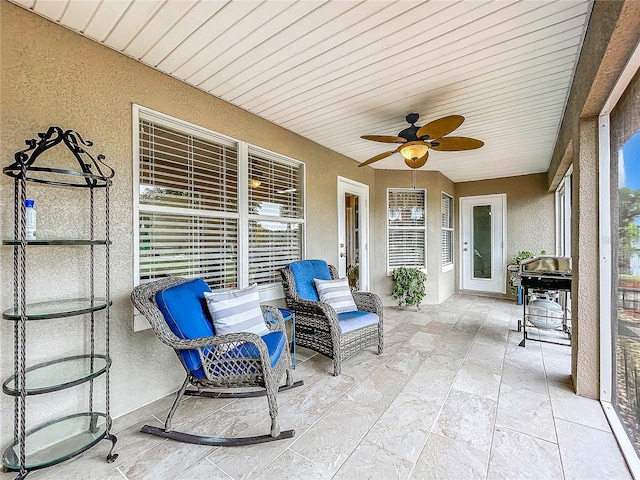 sunroom / solarium featuring wood ceiling and ceiling fan