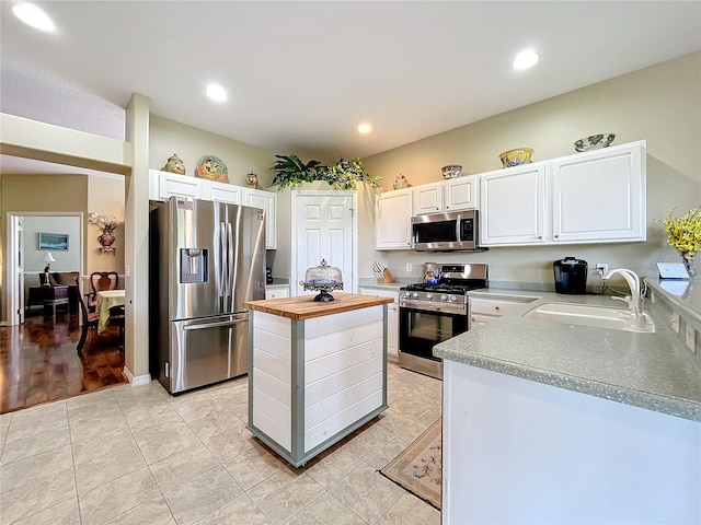 kitchen featuring light wood-type flooring, wood counters, appliances with stainless steel finishes, and white cabinets