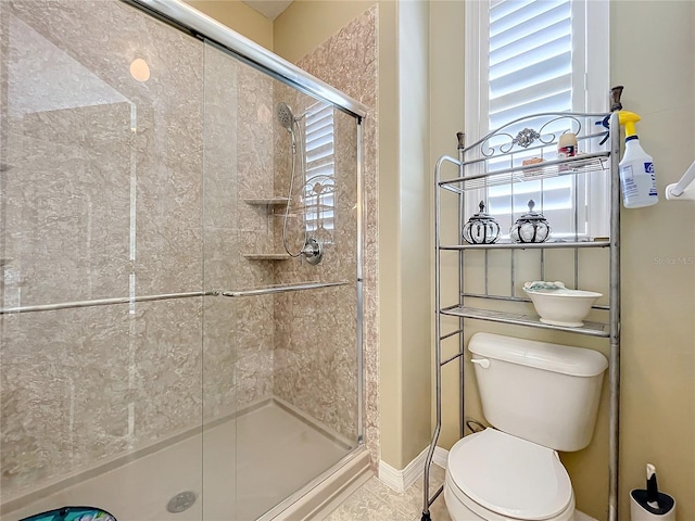 bathroom with toilet and a shower with door