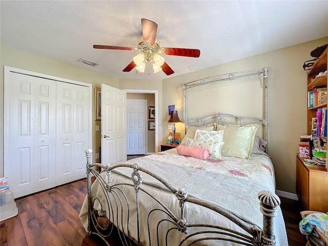 bedroom with a closet, ceiling fan, dark hardwood / wood-style floors, and a textured ceiling