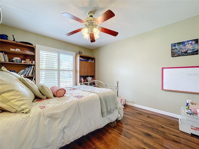 bedroom with ceiling fan, dark hardwood / wood-style flooring, and a textured ceiling