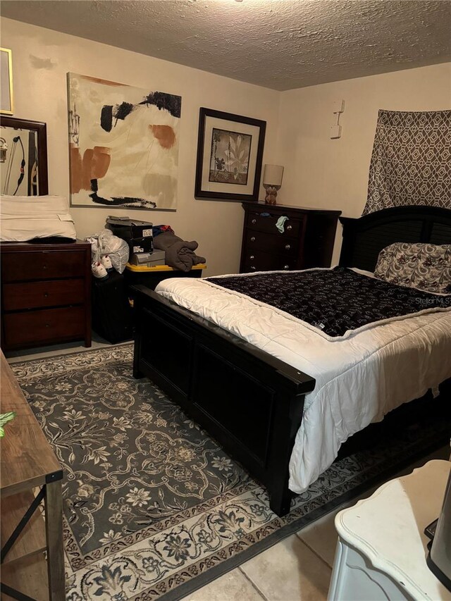 bedroom with tile patterned flooring and a textured ceiling