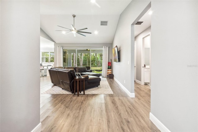 living room featuring light wood-type flooring, vaulted ceiling, and ceiling fan