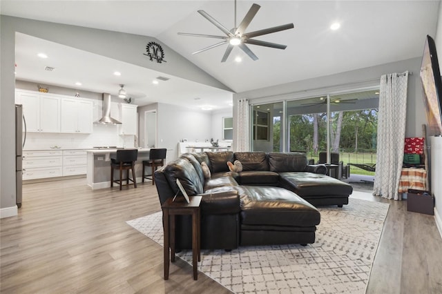 living room with light wood-type flooring, lofted ceiling, and ceiling fan