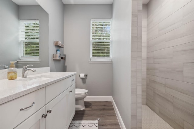 bathroom featuring a wealth of natural light, vanity, toilet, and hardwood / wood-style flooring