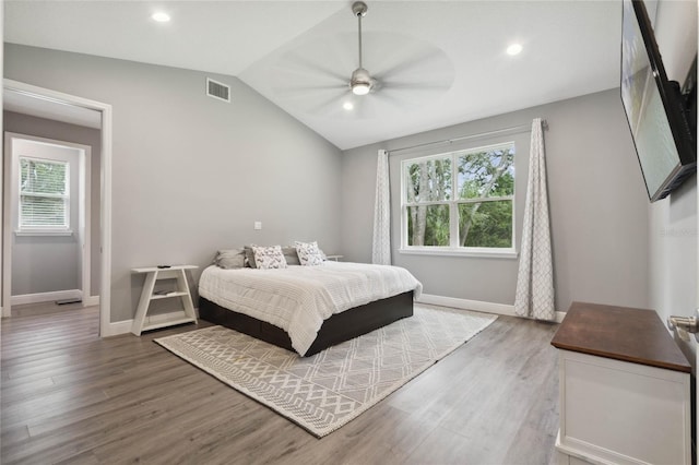 bedroom with multiple windows, vaulted ceiling, wood-type flooring, and ceiling fan