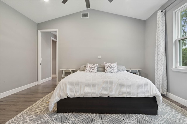 bedroom with lofted ceiling, ceiling fan, multiple windows, and hardwood / wood-style flooring