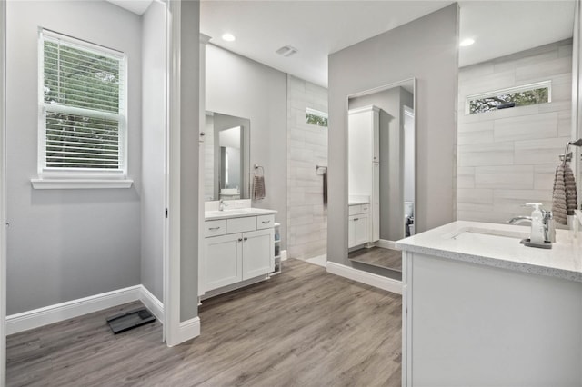 bathroom featuring vanity, hardwood / wood-style floors, and a tile shower