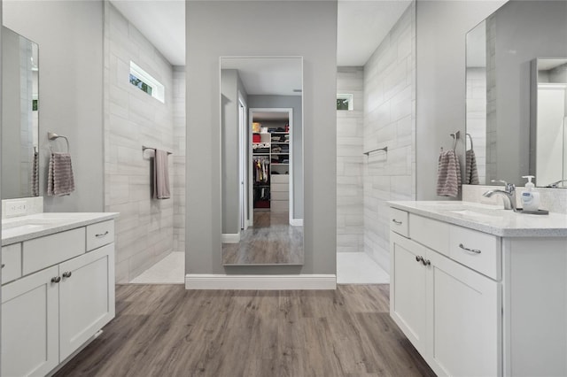 bathroom featuring vanity, hardwood / wood-style floors, and a tile shower