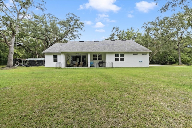 rear view of house featuring a yard