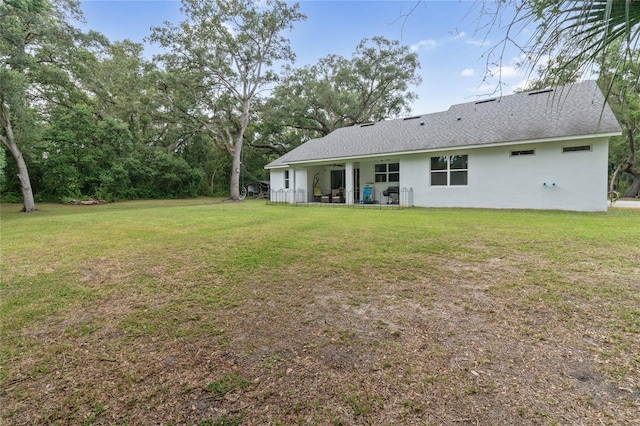 rear view of property with a lawn