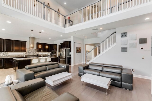 living room featuring a high ceiling and light wood-type flooring