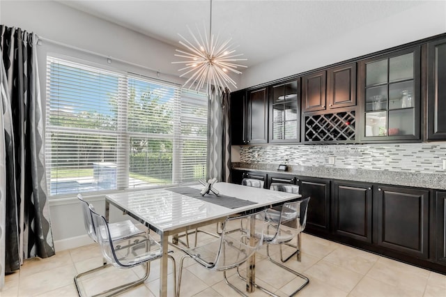 tiled dining space featuring plenty of natural light and a chandelier