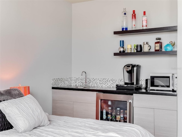 bedroom featuring beverage cooler and indoor wet bar