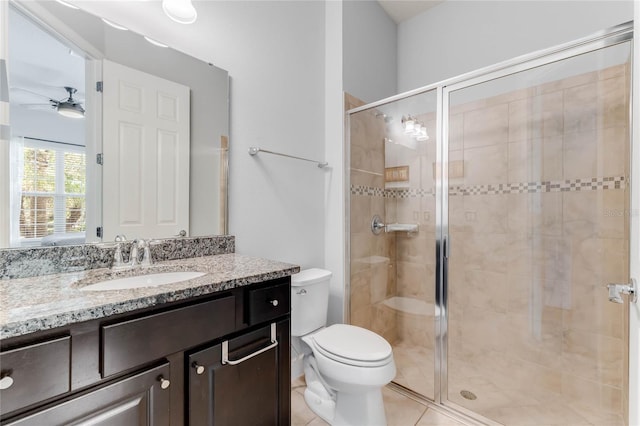 bathroom with a shower with shower door, tile patterned flooring, vanity, ceiling fan, and toilet