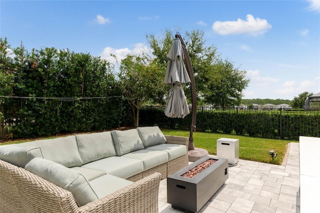 view of patio with an outdoor living space with a fire pit