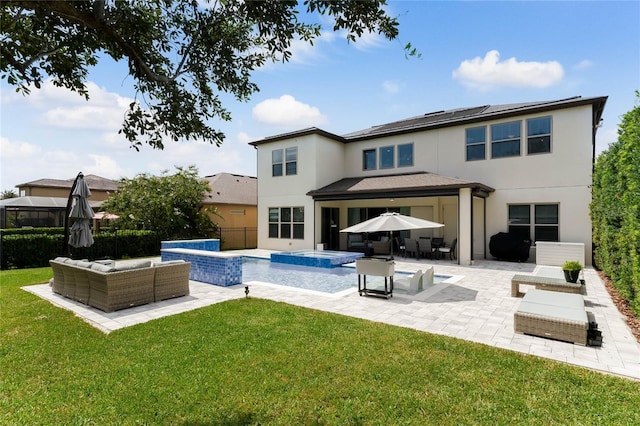 back of house with a patio, a lawn, an outdoor hangout area, a pool with hot tub, and solar panels