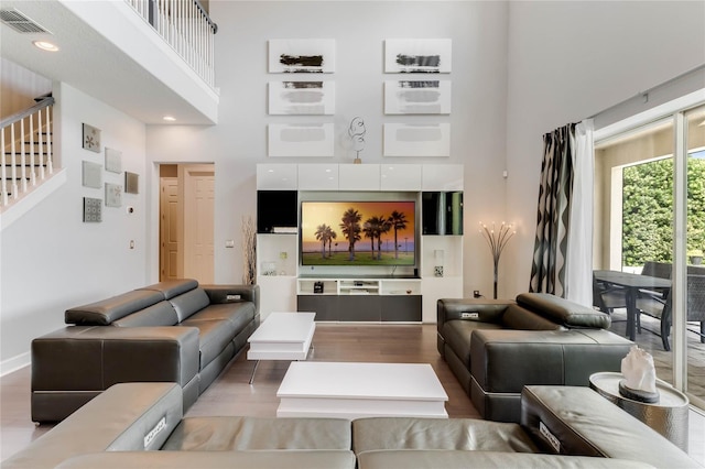 interior space with a towering ceiling and hardwood / wood-style flooring