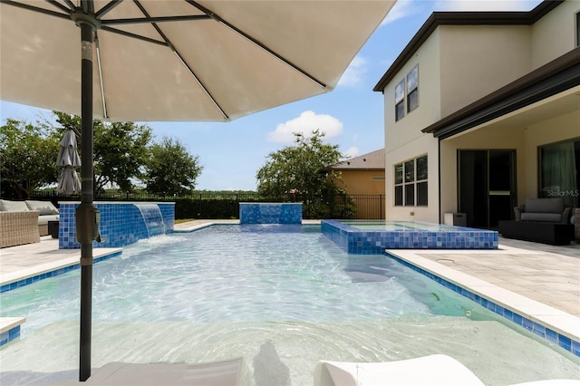 view of swimming pool with a patio, pool water feature, and an in ground hot tub