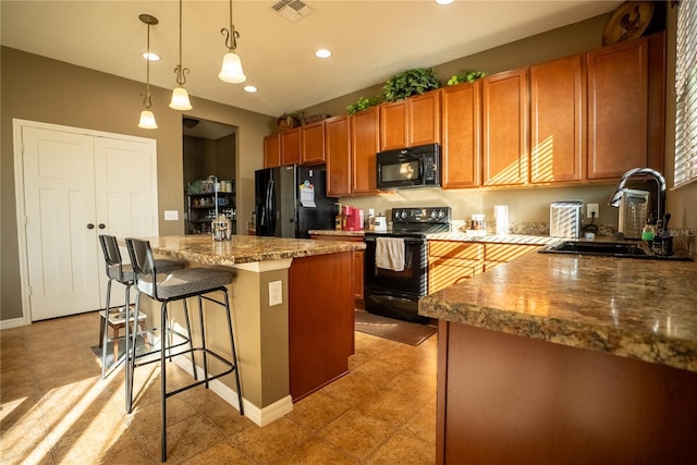 kitchen featuring visible vents, a kitchen island, brown cabinets, black appliances, and a sink