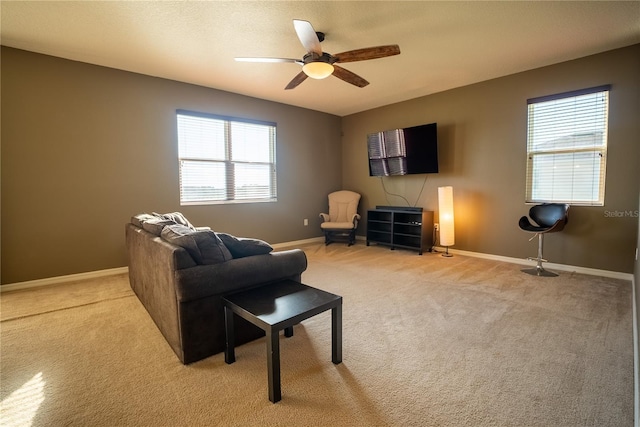 living area with light carpet, plenty of natural light, and baseboards