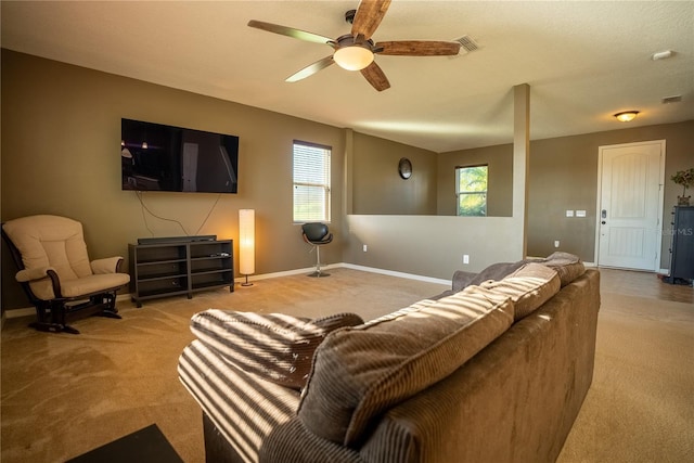 living area featuring carpet floors, baseboards, visible vents, and ceiling fan