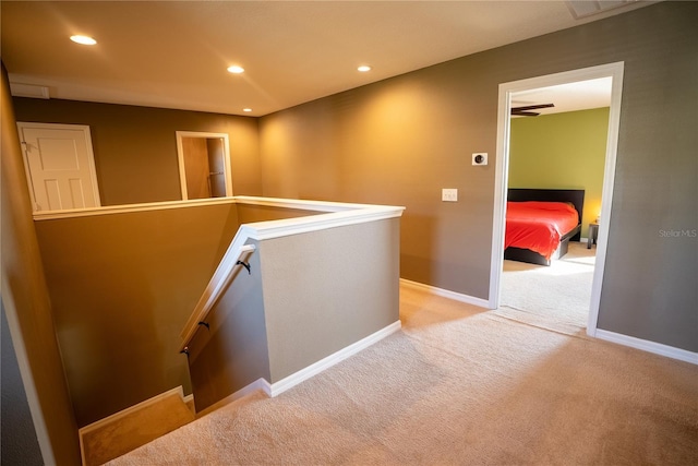 hall featuring recessed lighting, baseboards, carpet flooring, and an upstairs landing