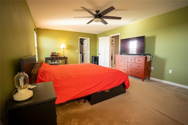 carpeted bedroom featuring baseboards, a spacious closet, visible vents, and a ceiling fan