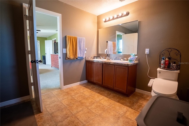 bathroom with a sink, baseboards, and double vanity