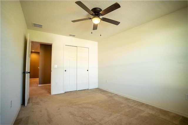 unfurnished bedroom featuring baseboards, visible vents, a closet, and light colored carpet