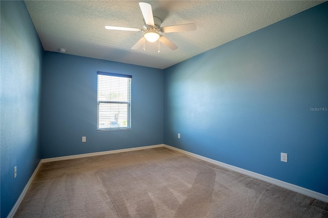 unfurnished room with carpet, ceiling fan, a textured ceiling, and baseboards